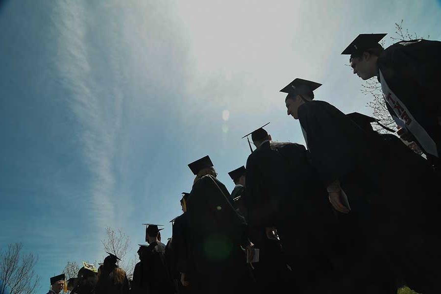 Students at commencement in  silhouette